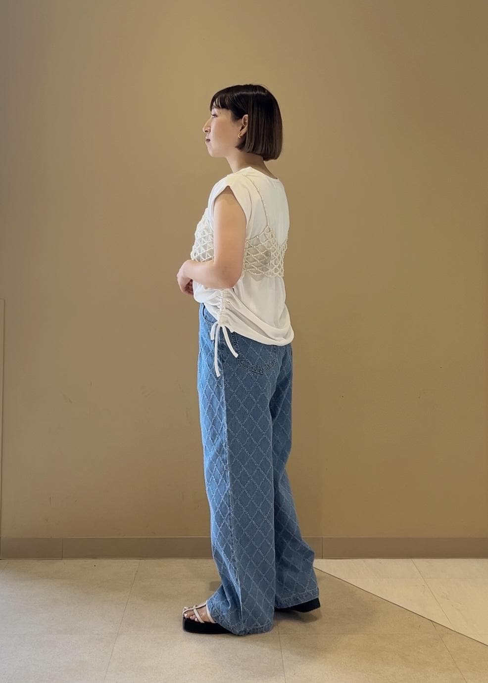 シルバー系のショルダーバッグ、ホワイト系のサンダル、ホワイト系のキャミソールを着用したレディースの春コーディネートの2枚目の写真