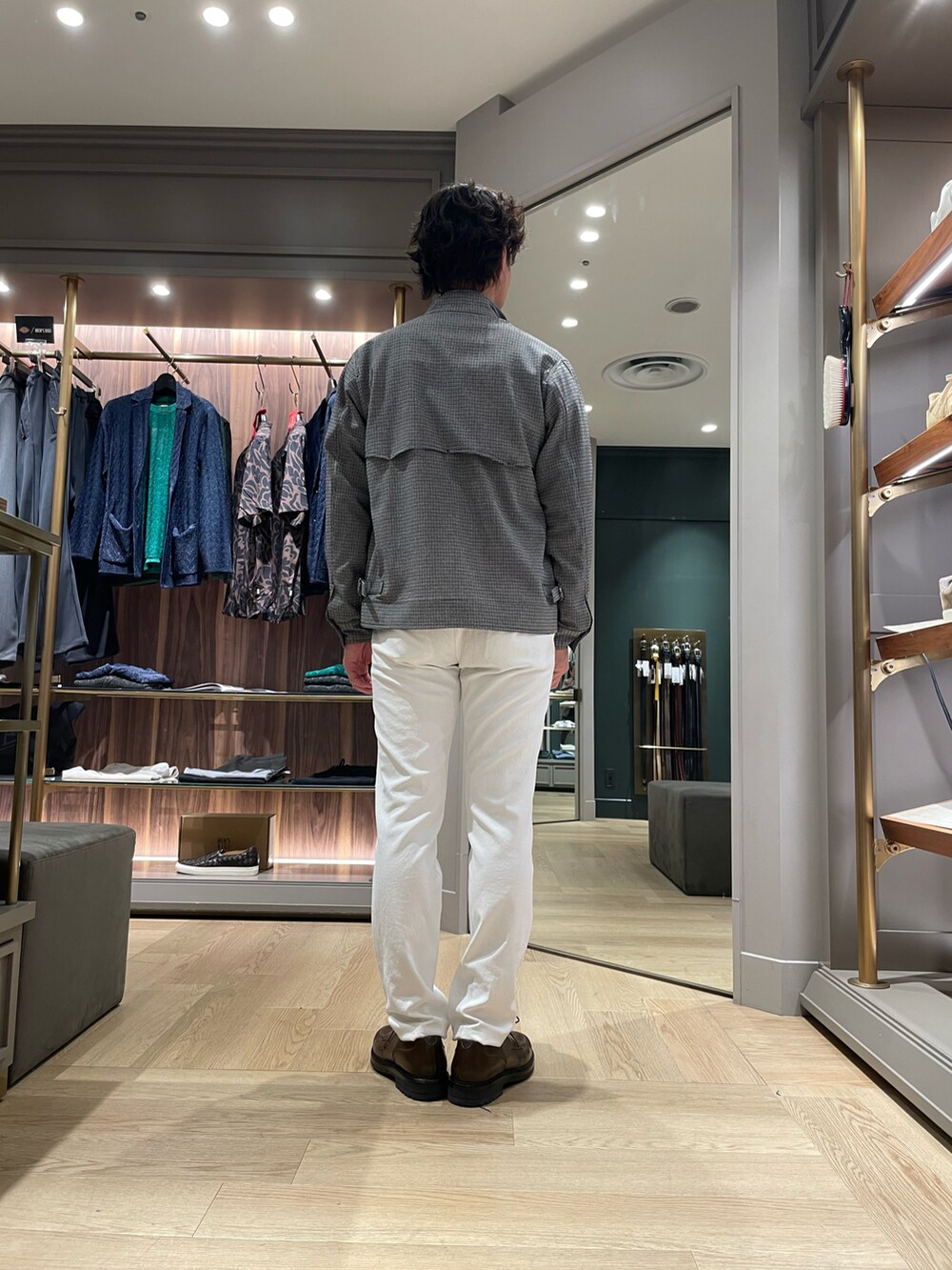 ブラウン系のドレスシューズ、ホワイト系のその他パンツ、ブラック系のブルゾンを着用したメンズの春コーディネートの2枚目の写真
