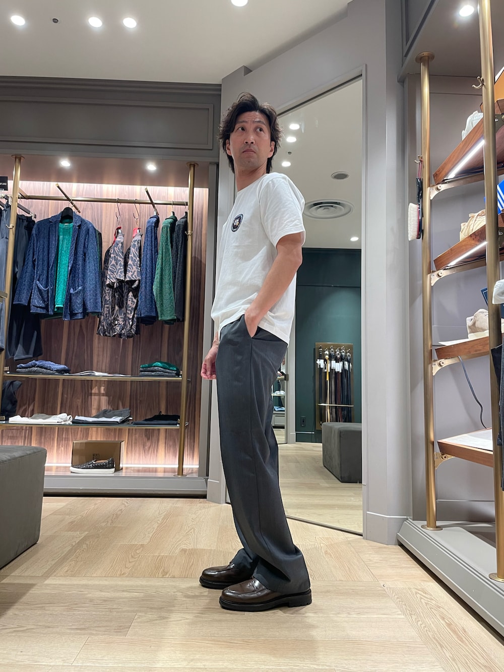 ホワイト系のTシャツ/カットソー、グレー系のパンツ、ブラウン系のドレスシューズを着用したメンズの春コーディネートの2枚目の写真