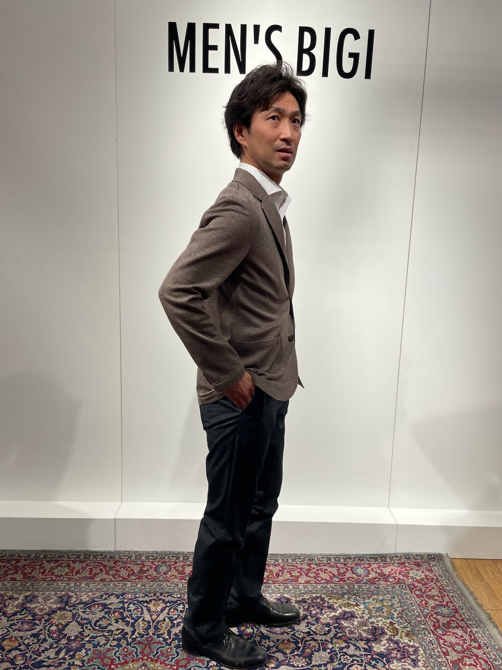 ベージュ系のテーラードジャケット、ブラック系のスラックス、ホワイト系のシャツ/ブラウスを着用したメンズの春コーディネートの2枚目の写真