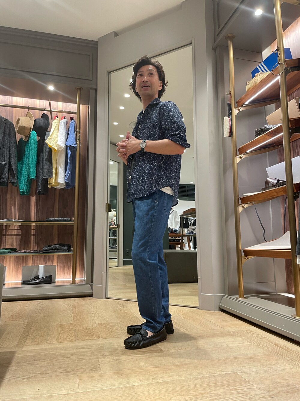ブルー系のシャツ/ブラウス、ブルー系のデニムパンツ、ブラック系のモカシン/デッキシューズを着用したメンズの夏コーディネートの2枚目の写真