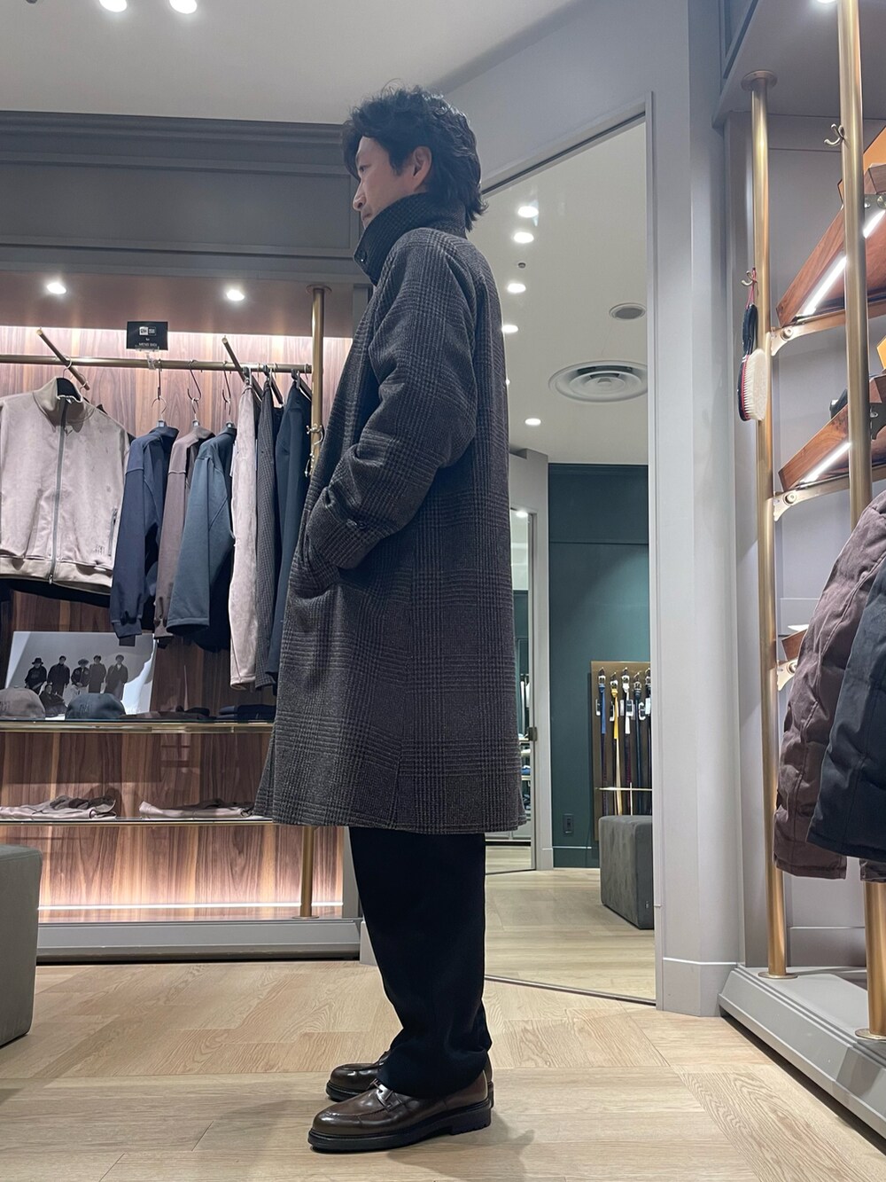 ブラウン系のダウンジャケット/コート、ブラック系のスラックス、ブラウン系のドレスシューズを着用したメンズの冬コーディネートの3枚目の写真