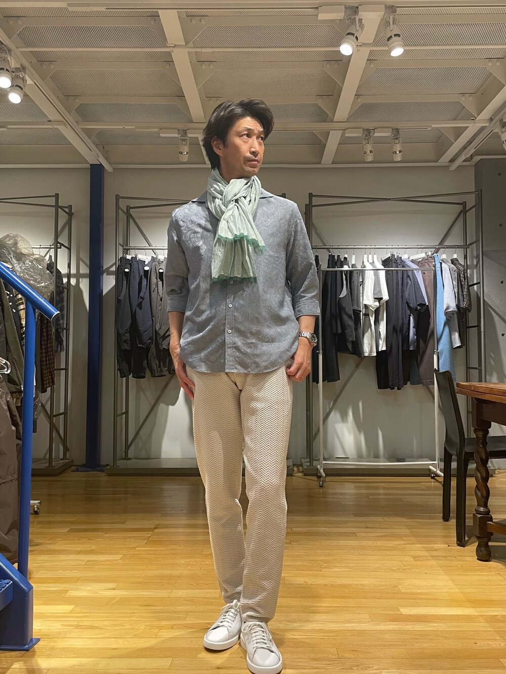 ブルー系のシャツ/ブラウス、ホワイト系のスラックス、ホワイト系のスニーカーを着用したメンズの春コーディネートの2枚目の写真