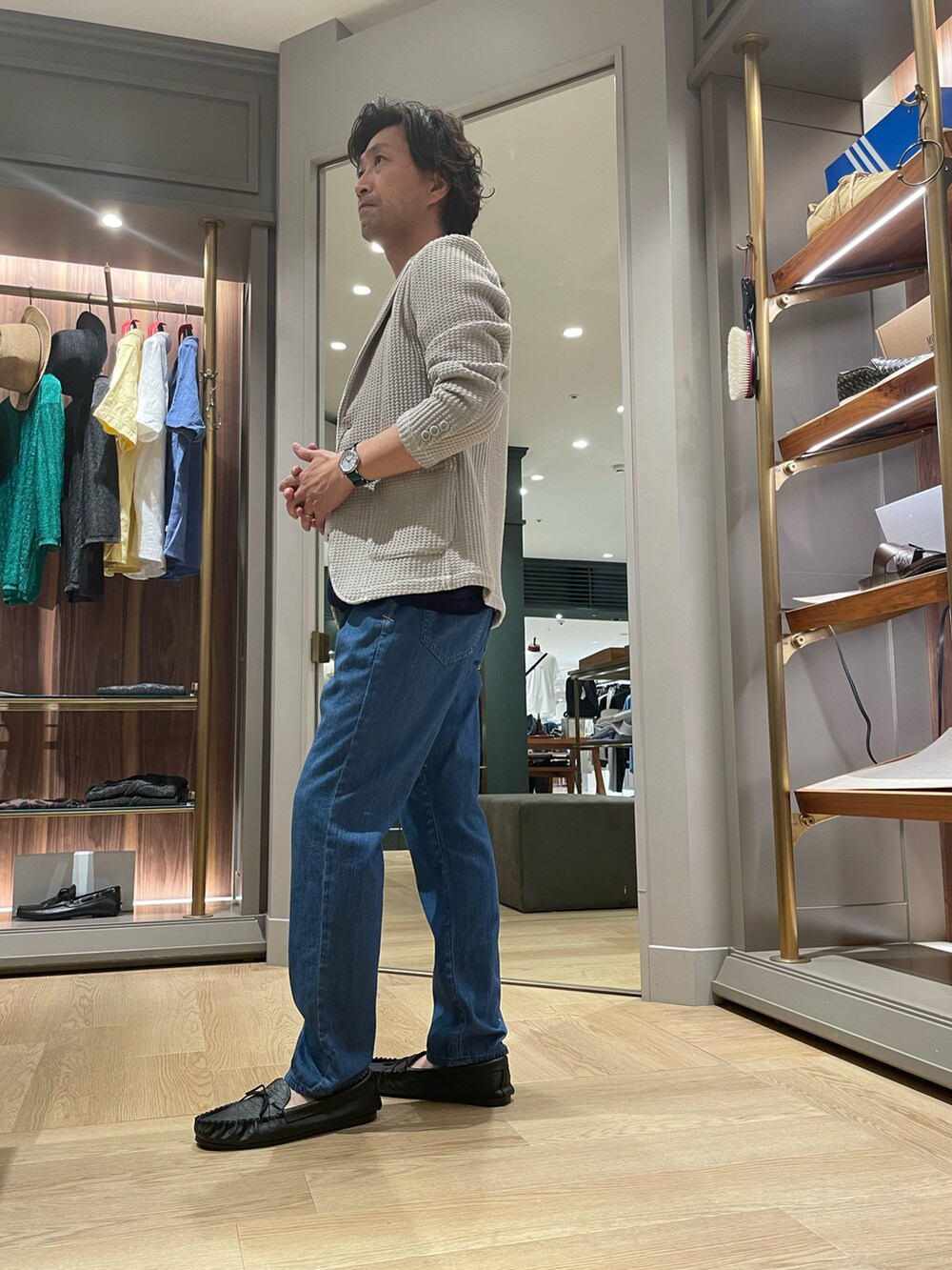 ベージュ系のテーラードジャケット、ブラック系のTシャツ/カットソー、ブルー系のデニムパンツを着用したメンズの夏コーディネートの4枚目の写真