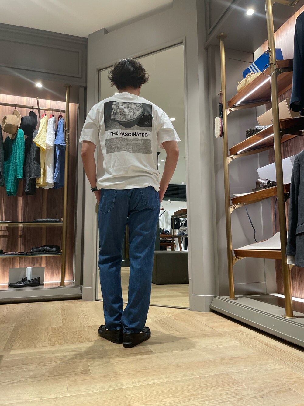 ホワイト系のTシャツ/カットソー、ブルー系のデニムパンツ、ブラック系のモカシン/デッキシューズを着用したメンズの夏コーディネートの3枚目の写真
