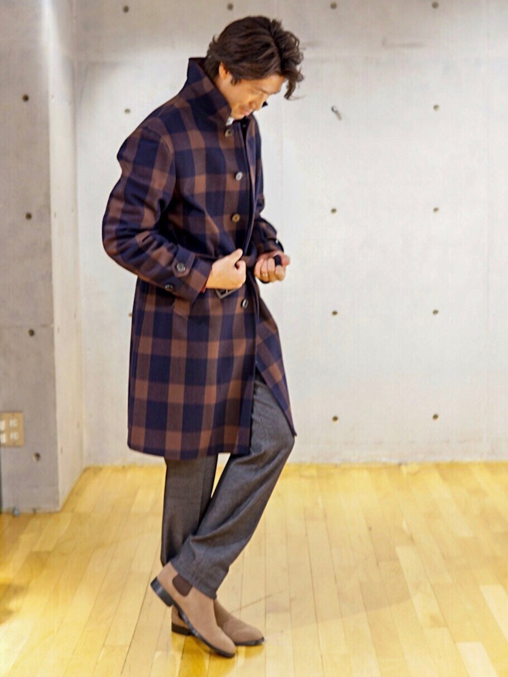 ブラウン系のステンカラーコートを着用したメンズの秋コーディネートの3枚目の写真