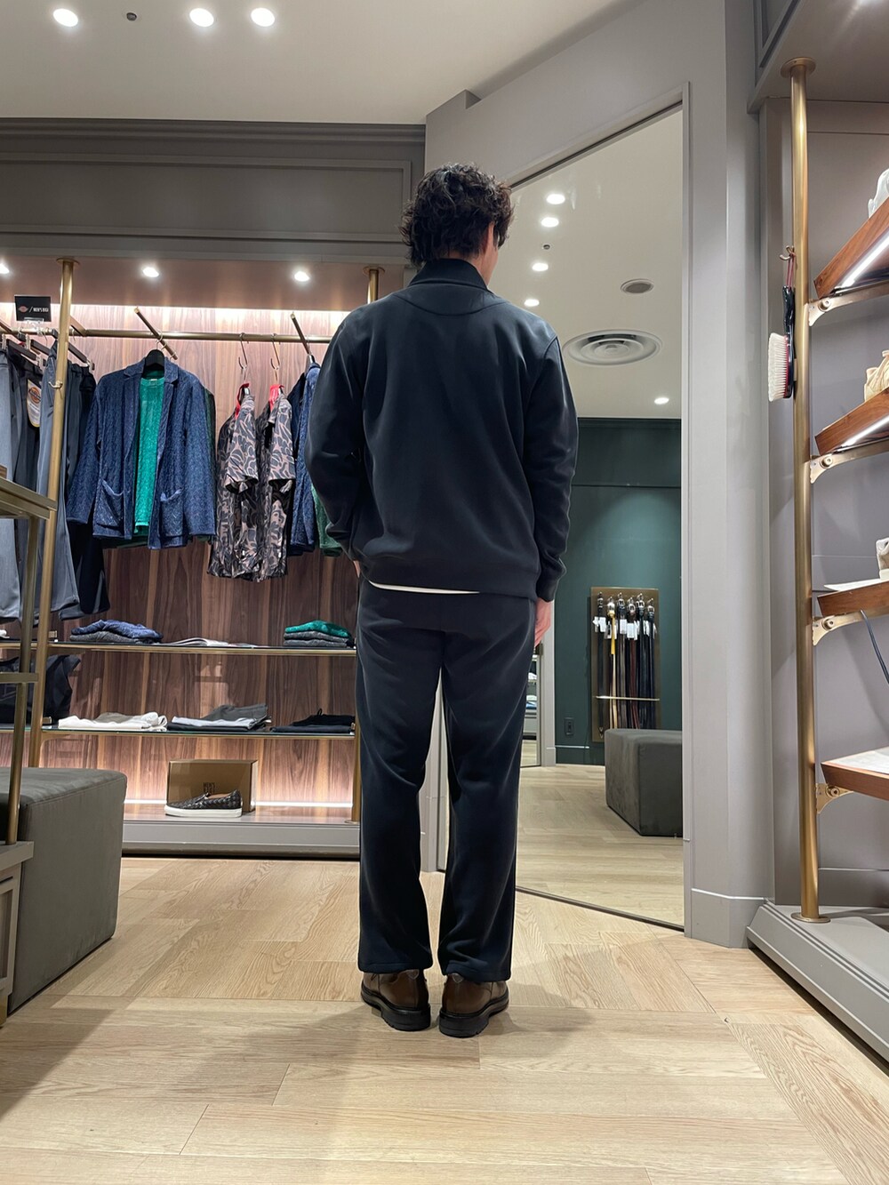 ブラック系のその他アウター、ブラック系のスウェットパンツ、ブラウン系のドレスシューズを着用したメンズの春コーディネートの4枚目の写真