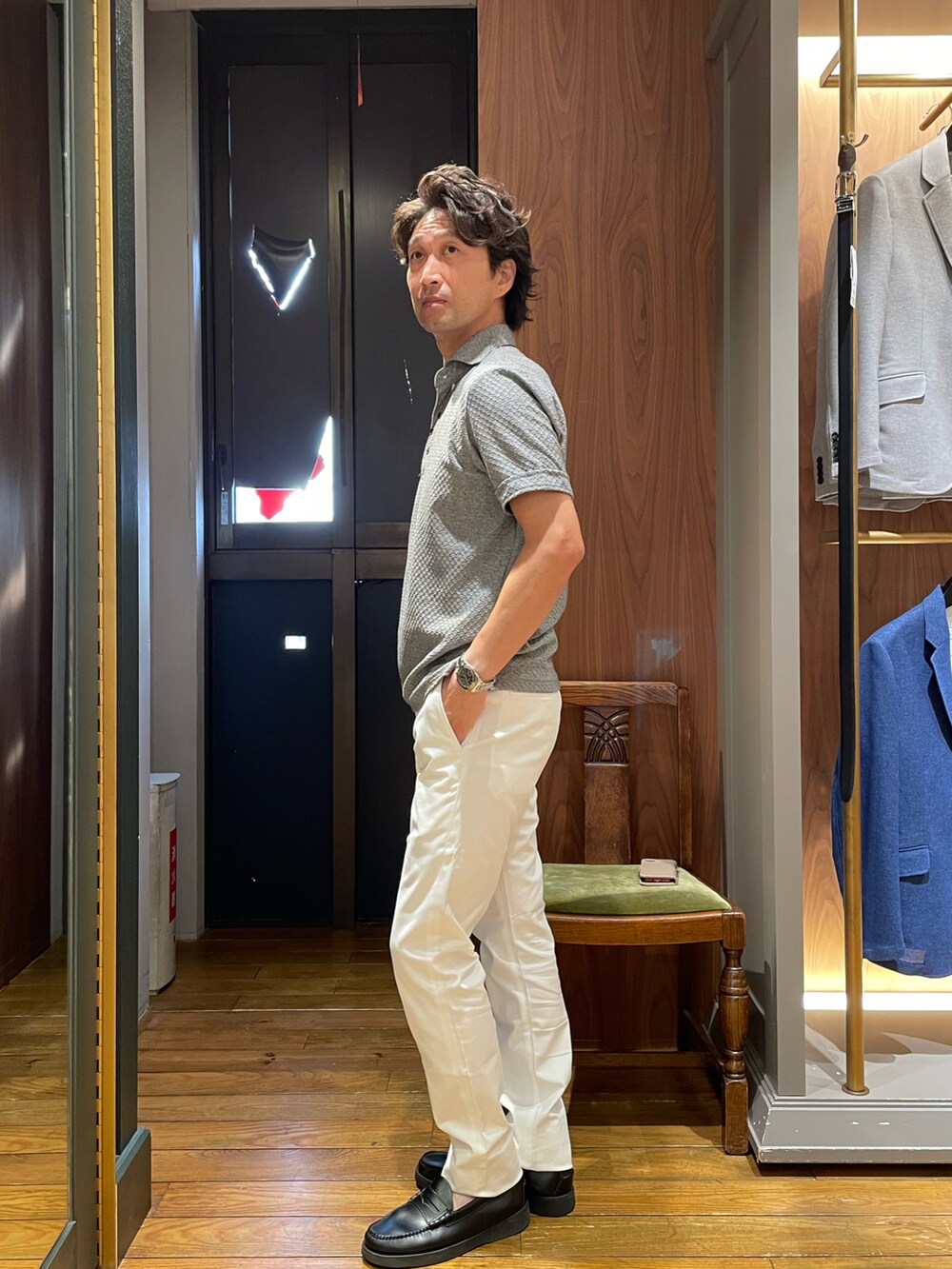グレー系のポロシャツ、ホワイト系のスラックスを着用したメンズの夏コーディネートの2枚目の写真