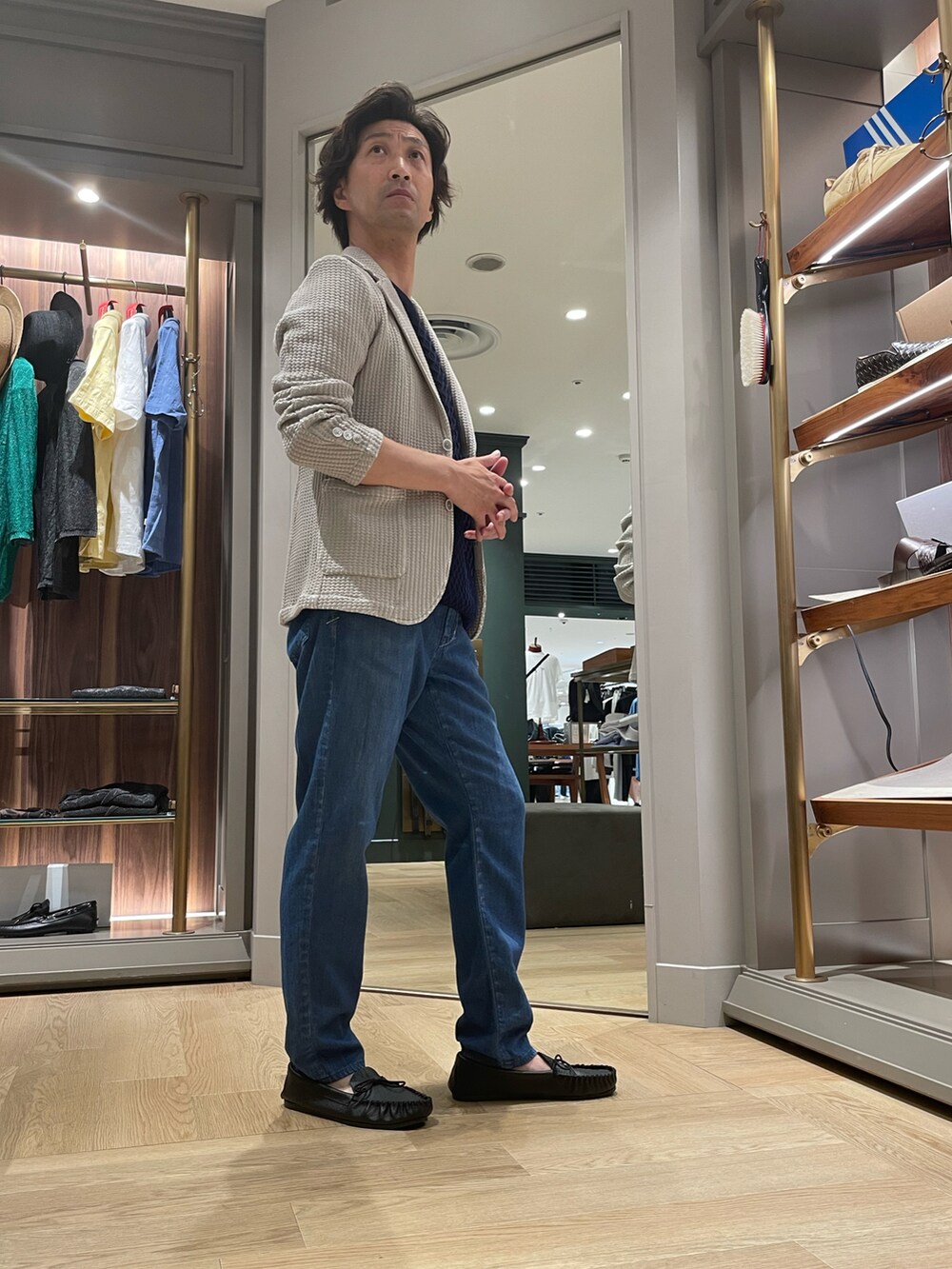 ベージュ系のテーラードジャケット、ブラック系のTシャツ/カットソー、ブルー系のデニムパンツを着用したメンズの夏コーディネートの2枚目の写真