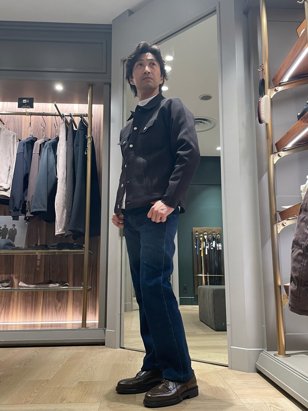 ブラック系のブルゾン、ブルー系のデニムパンツ、ブラウン系のドレスシューズを着用したメンズの冬コーディネートの2枚目の写真