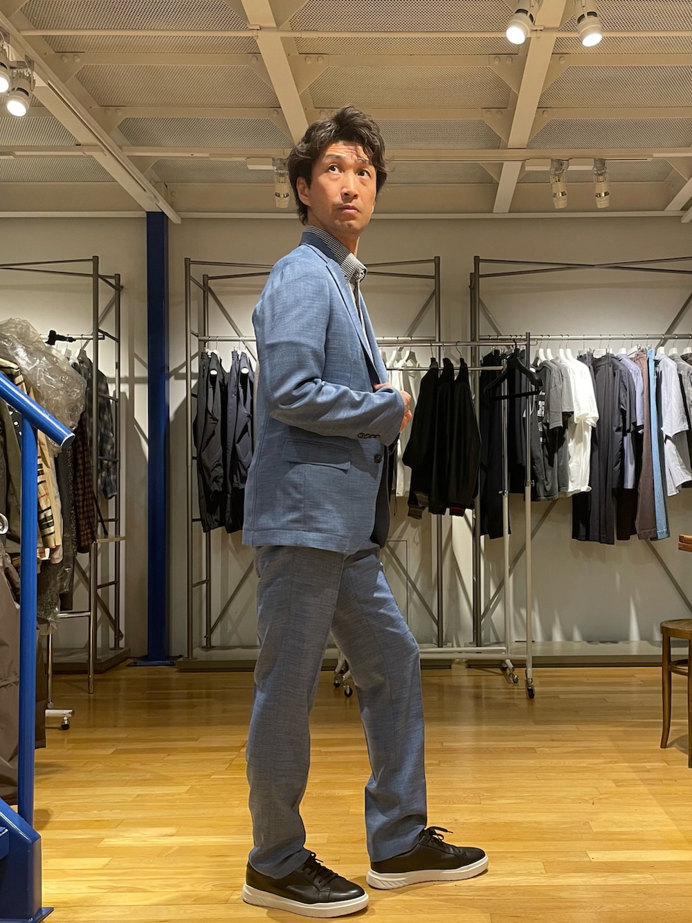 ブルー系のテーラードジャケット、ブルー系のスラックス、ブルー系のポロシャツを着用したメンズの春コーディネートの2枚目の写真