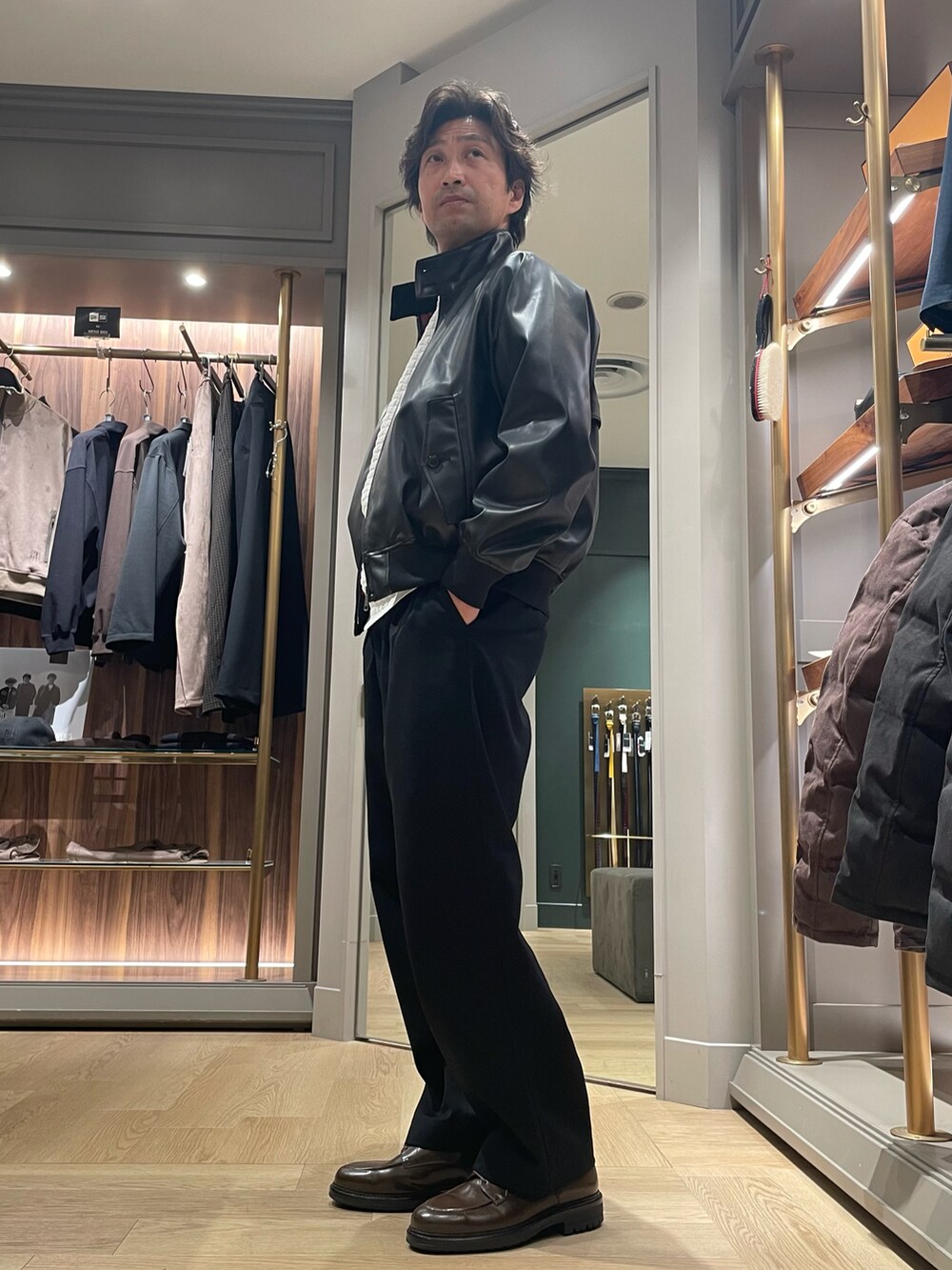 ブラック系のライダースジャケット、ホワイト系のTシャツ/カットソー、ブラック系のスラックスを着用したメンズの冬コーディネートの3枚目の写真