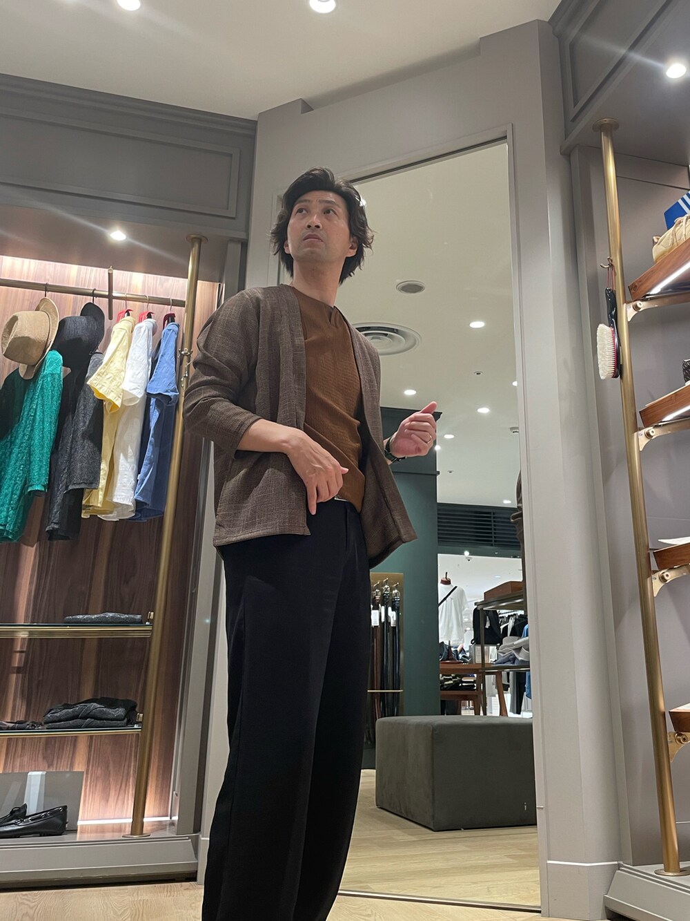 ブラウン系のカーディガン/ボレロ、ブルー系のその他パンツ、ブラック系のモカシン/デッキシューズを着用したメンズの夏コーディネートの4枚目の写真