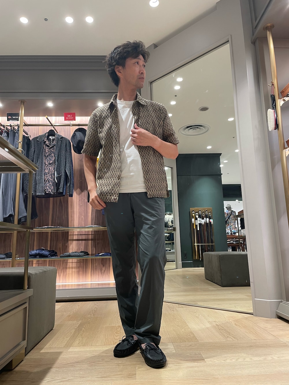 ブラウン系のシャツ/ブラウス、グレー系のパンツ、ブラック系のモカシン/デッキシューズを着用したメンズの秋コーディネートの4枚目の写真