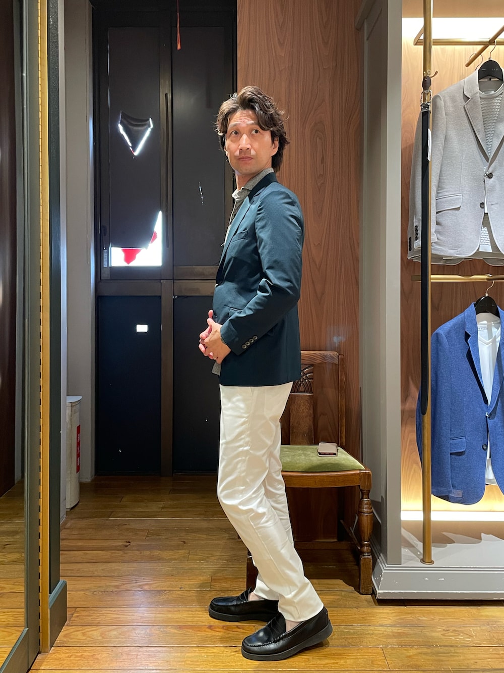 グレー系のポロシャツ、グリーン系のテーラードジャケット、ホワイト系のスラックスを着用したメンズの夏コーディネートの2枚目の写真