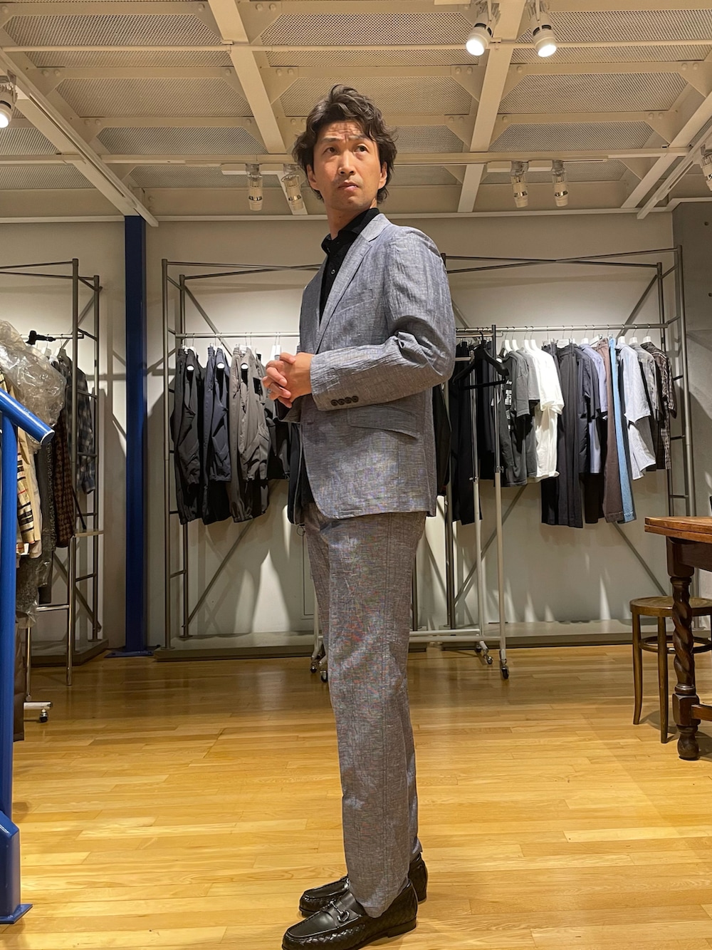 グレー系のテーラードジャケット、グレー系のスラックス、ブラック系のローファーを着用したメンズの春コーディネートの2枚目の写真