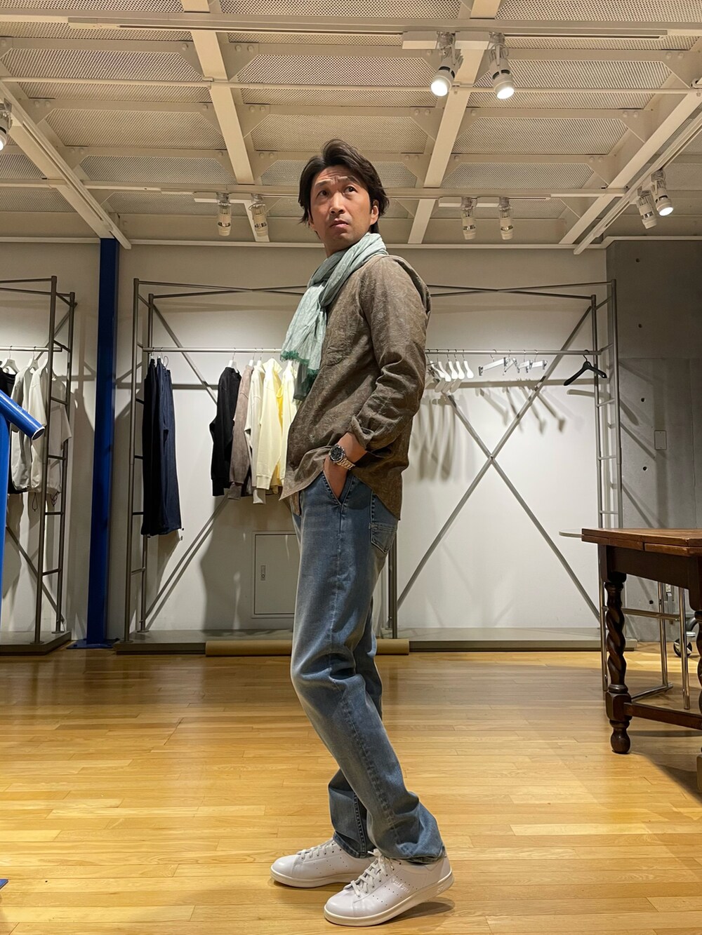 ブラウン系のシャツ/ブラウス、ブルー系のデニムパンツ、ホワイト系のスニーカーを着用したメンズの春コーディネートの2枚目の写真