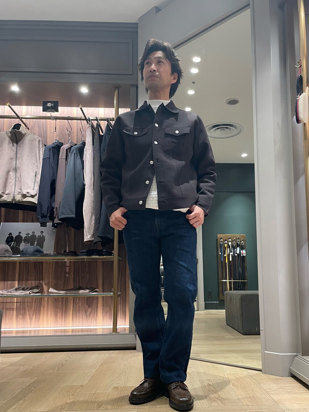 ブラック系のブルゾン、ブルー系のデニムパンツ、ブラウン系のドレスシューズを着用したメンズの冬コーディネートの3枚目の写真