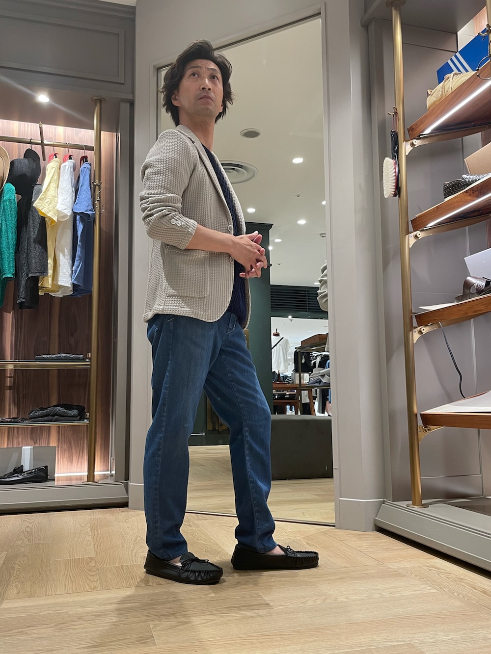 ホワイト系のテーラードジャケット、ブラック系のTシャツ/カットソー、ブルー系のデニムパンツを着用したメンズの夏コーディネートの4枚目の写真