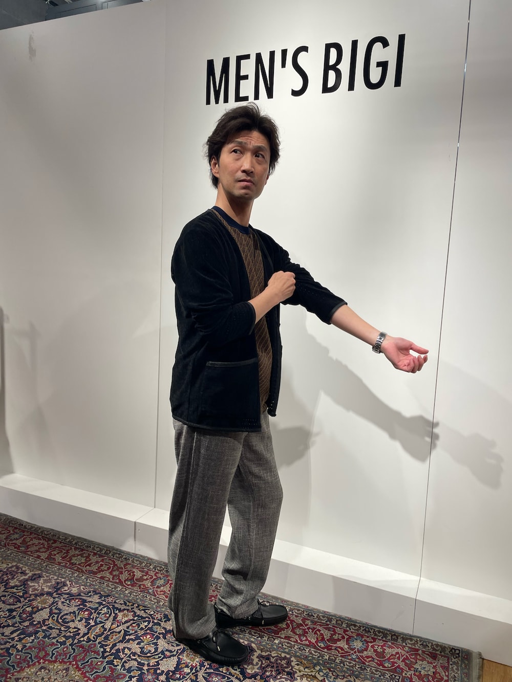 ブラック系のカーディガン/ボレロ、グレー系のパンツ、ブラック系のモカシン/デッキシューズを着用したメンズの春コーディネートの3枚目の写真