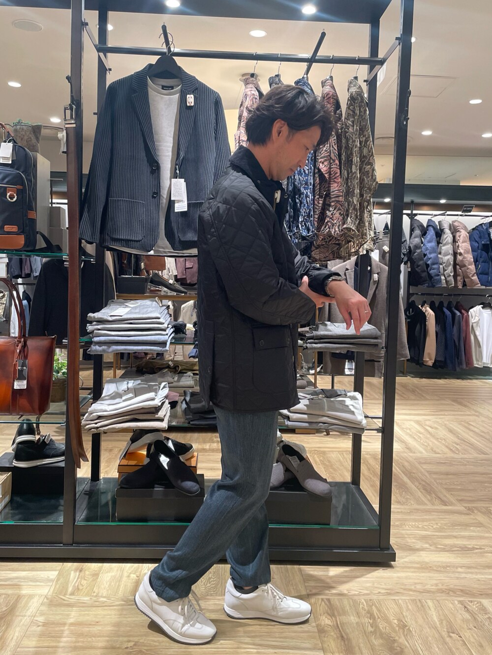 ブラック系のブルゾン、ブルー系のスラックス、イエロー系のニット/セーターを着用したメンズの秋コーディネートの2枚目の写真