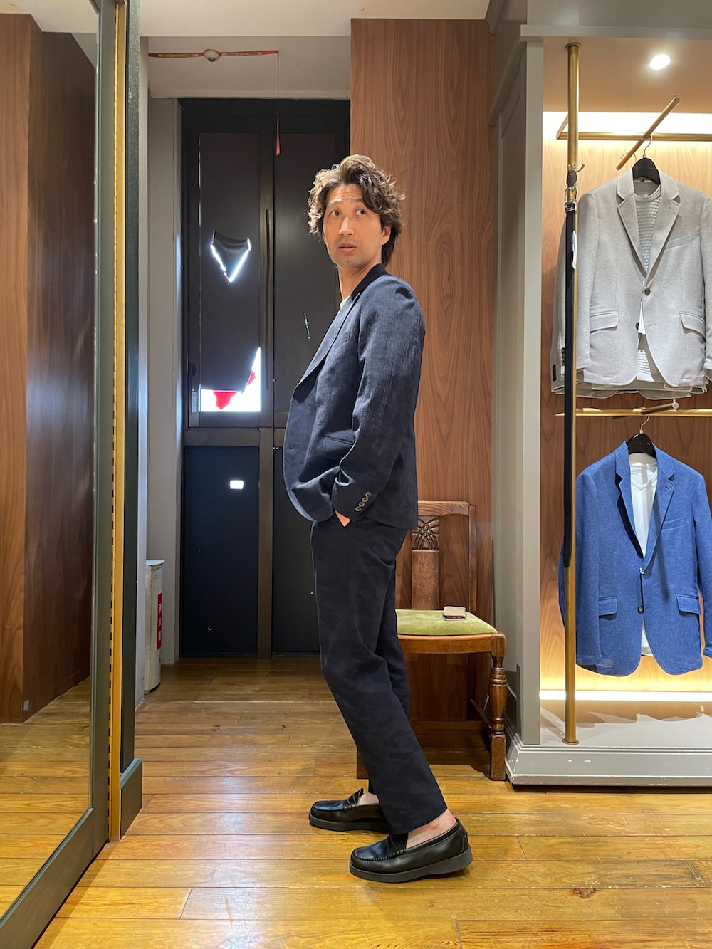 ホワイト系のTシャツ/カットソー、ブルー系のテーラードジャケット、ブルー系のスラックスを着用したメンズの夏コーディネートの2枚目の写真