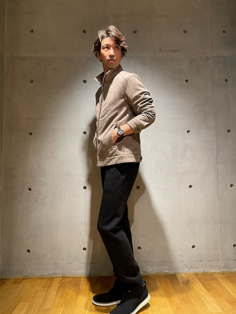 ベージュ系のブルゾン、ブラック系のスラックス、ブラック系のスニーカーを着用したメンズの秋コーディネートの2枚目の写真