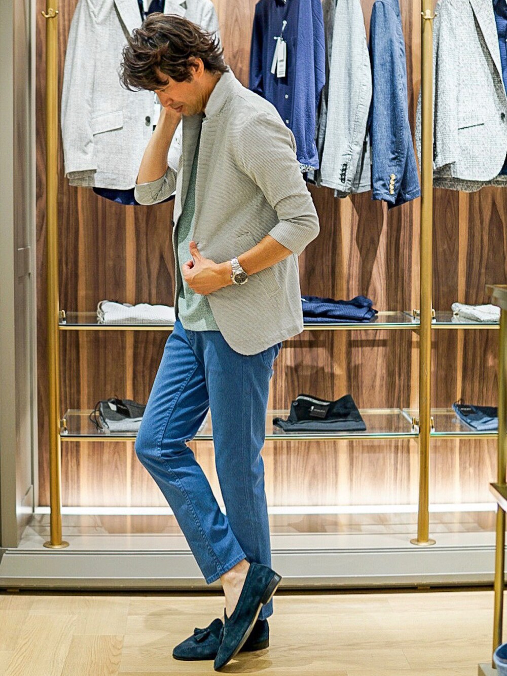 グリーン系のTシャツ/カットソー、ブルー系のデニムパンツ、ホワイト系のテーラードジャケットを着用したメンズの夏コーディネートの2枚目の写真