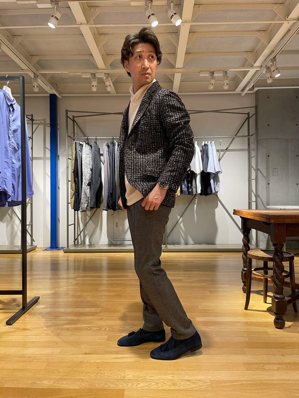 ブラック系のテーラードジャケット、グレー系のスラックス、ホワイト系のパーカーを着用したメンズの秋コーディネートの2枚目の写真