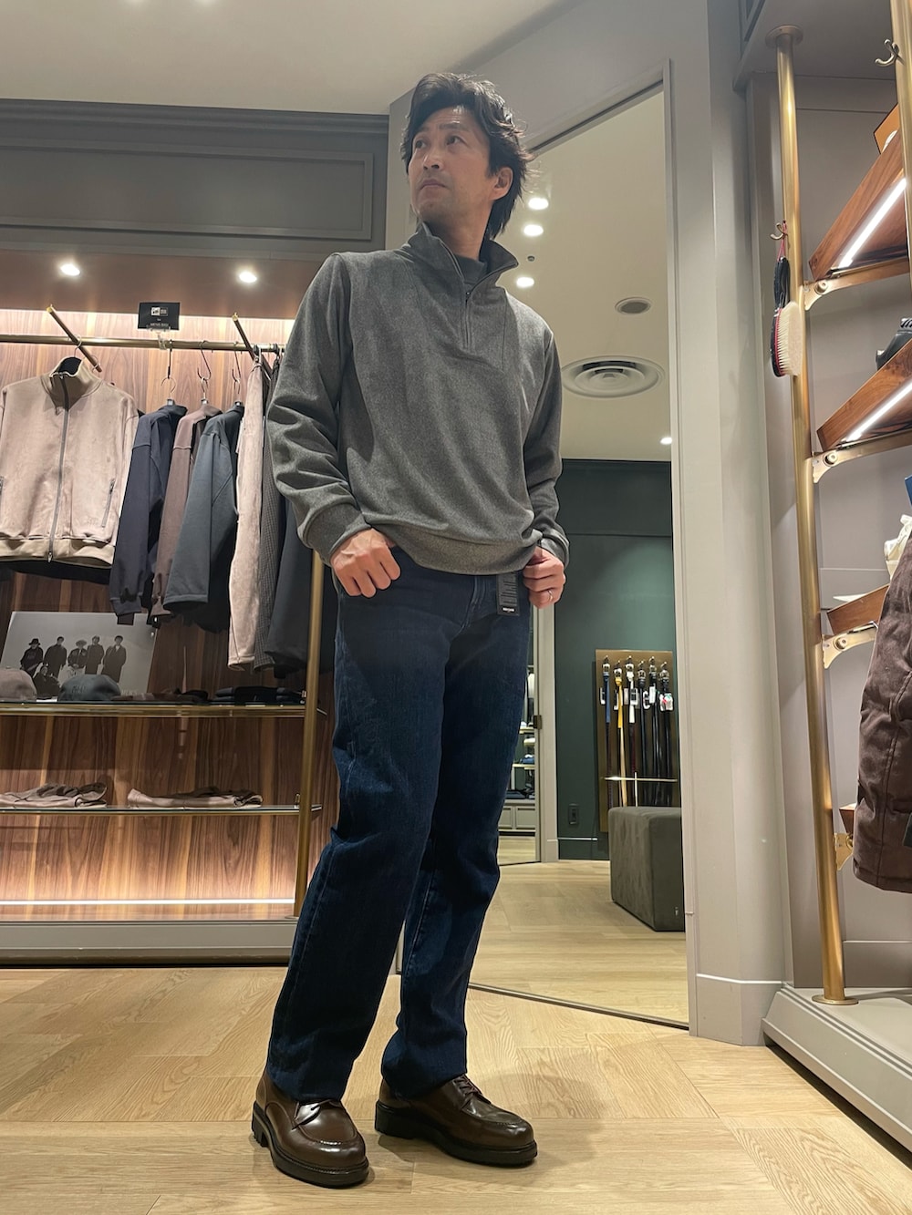 グレー系のTシャツ/カットソー、ブルー系のデニムパンツ、ブラウン系のドレスシューズを着用したメンズの冬コーディネートの3枚目の写真