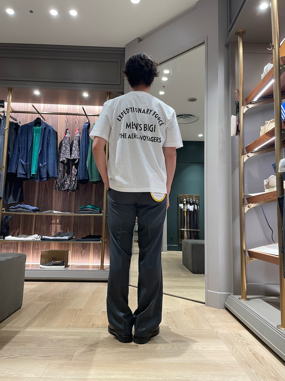 ホワイト系のTシャツ/カットソー、グレー系のパンツ、ブラウン系のドレスシューズを着用したメンズの春コーディネートの3枚目の写真
