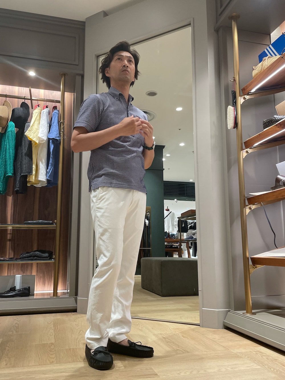 ブルー系のポロシャツ、ホワイト系のその他パンツ、ブラック系のモカシン/デッキシューズを着用したメンズの夏コーディネートの3枚目の写真
