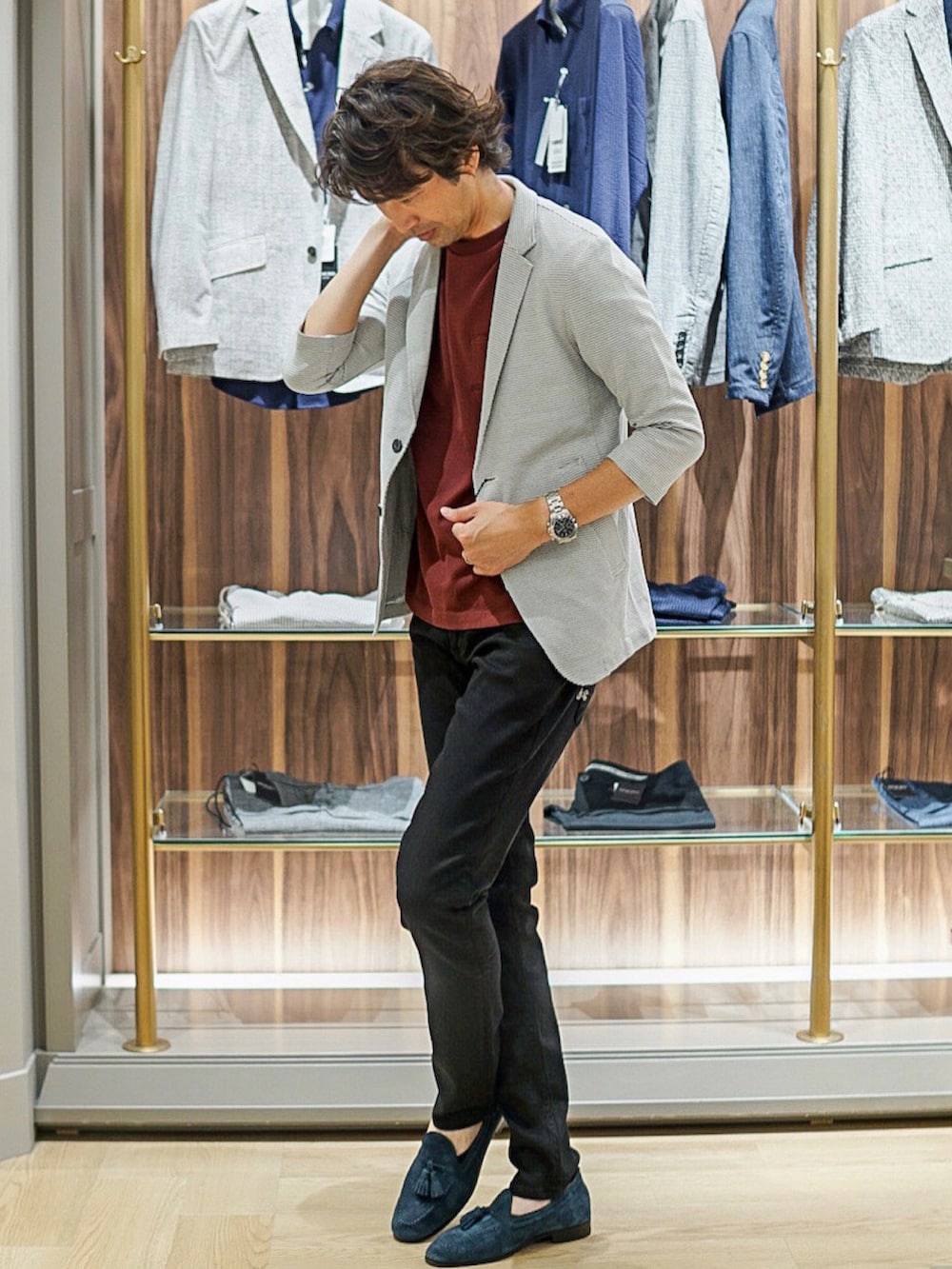 ブラック系のデニムパンツ、ホワイト系のテーラードジャケット、レッド系のTシャツ/カットソーを着用したメンズの夏コーディネートの2枚目の写真
