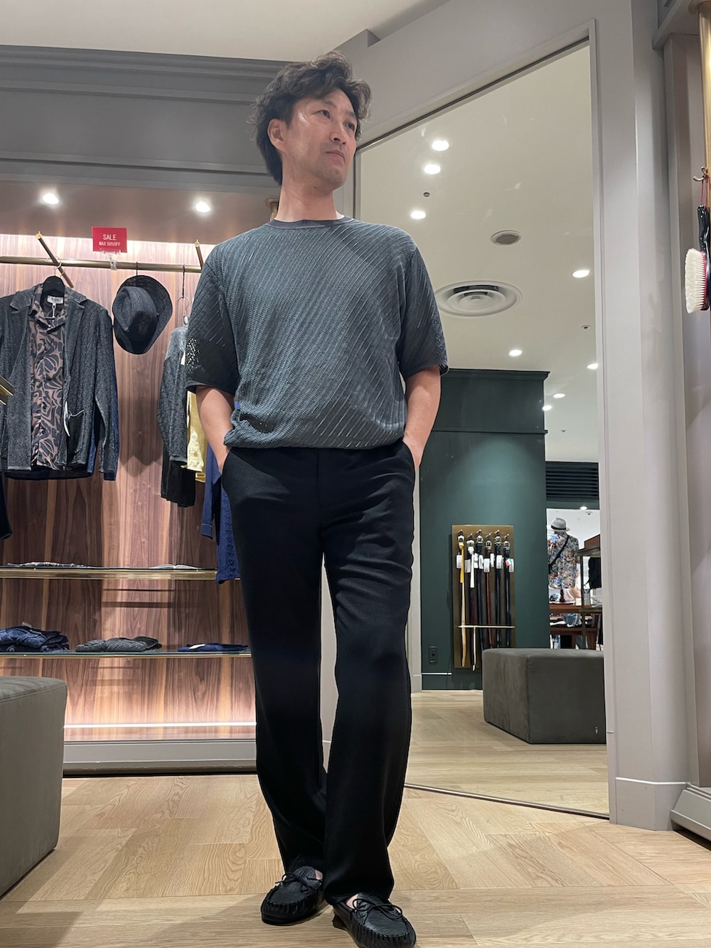 グリーン系のTシャツ/カットソー、ブラック系のその他パンツ、ブラック系のモカシン/デッキシューズを着用したメンズの夏コーディネートの4枚目の写真
