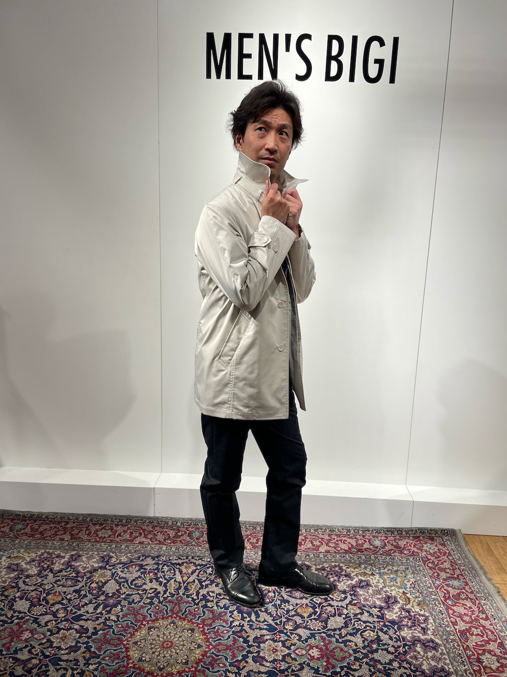 ホワイト系のステンカラーコートを着用したメンズの冬コーディネートの2枚目の写真