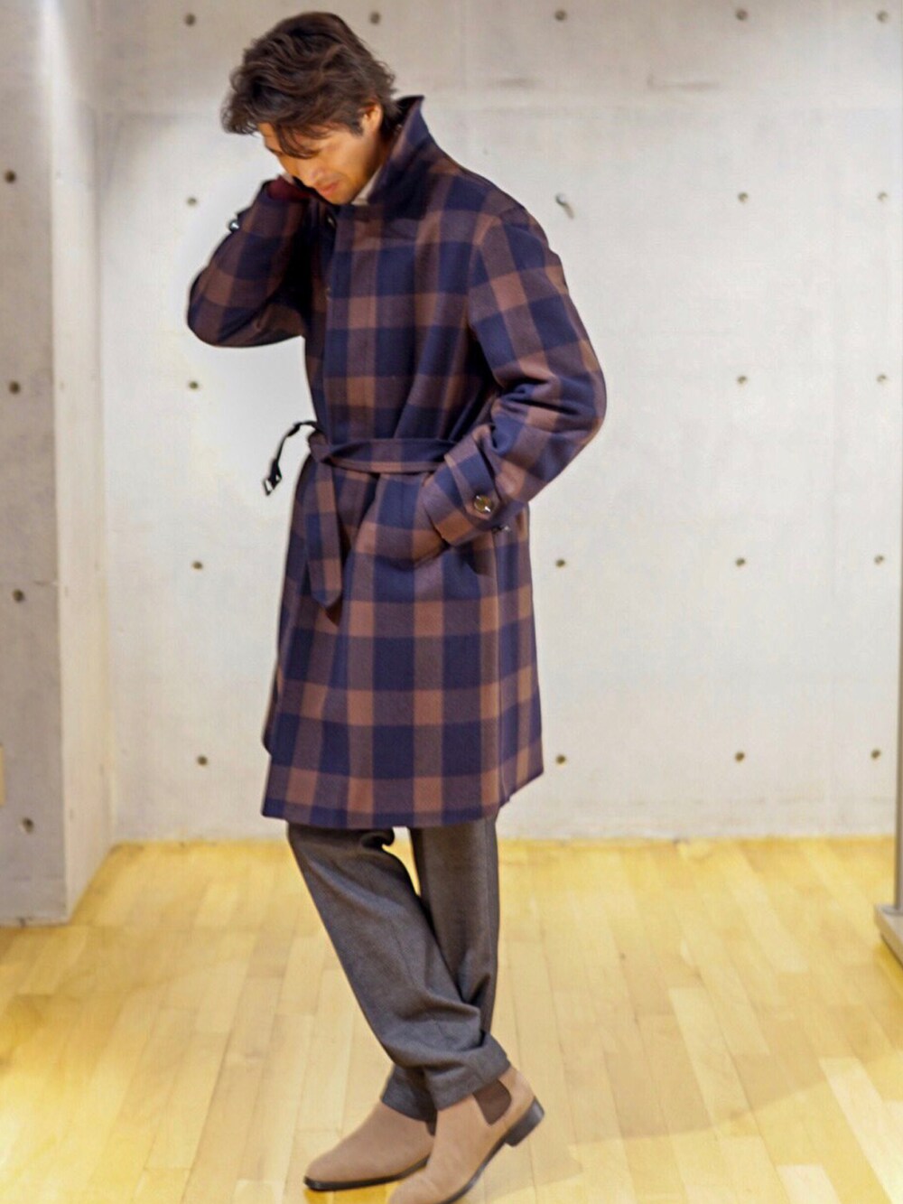 ブラウン系のステンカラーコートを着用したメンズの秋コーディネートの2枚目の写真