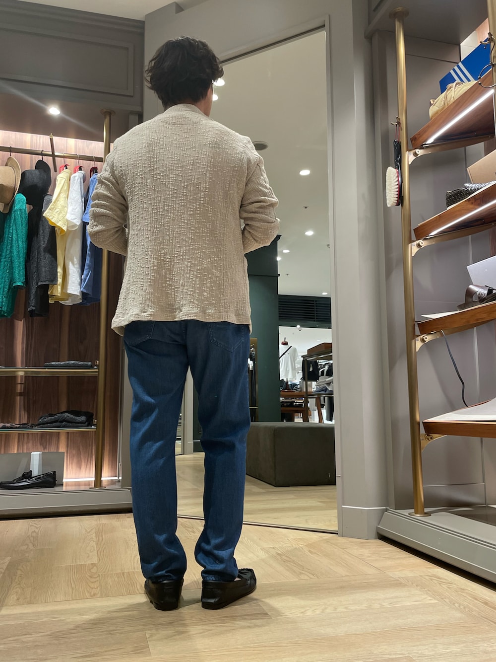 ブルー系のテーラードジャケット、ブルー系のデニムパンツ、ブラック系のモカシン/デッキシューズを着用したメンズの夏コーディネートの2枚目の写真
