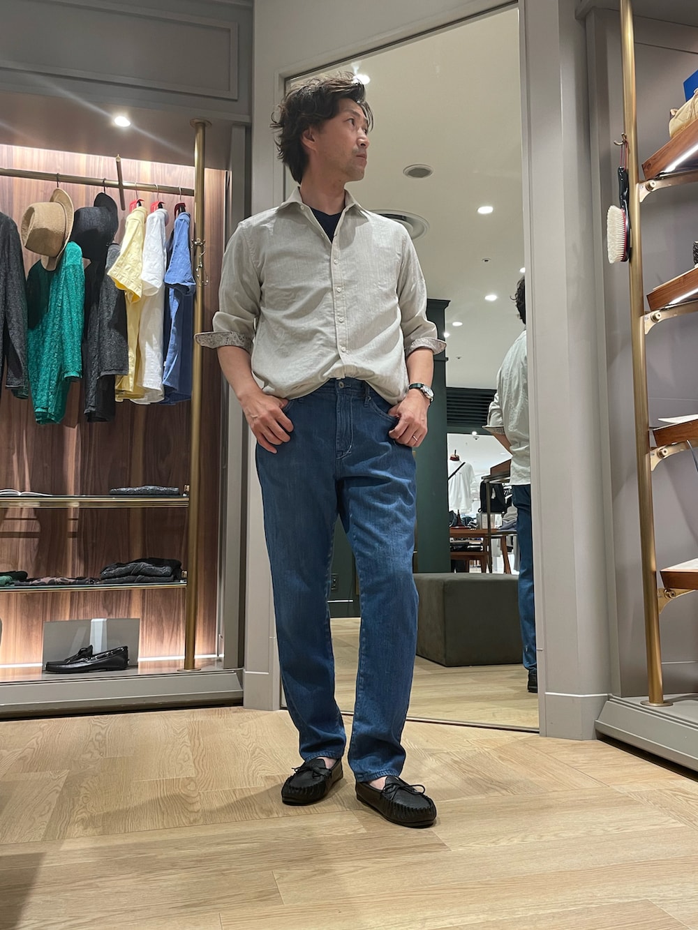 グレー系のシャツ/ブラウス、ブルー系のデニムパンツ、ブラック系のモカシン/デッキシューズを着用したメンズの夏コーディネートの4枚目の写真