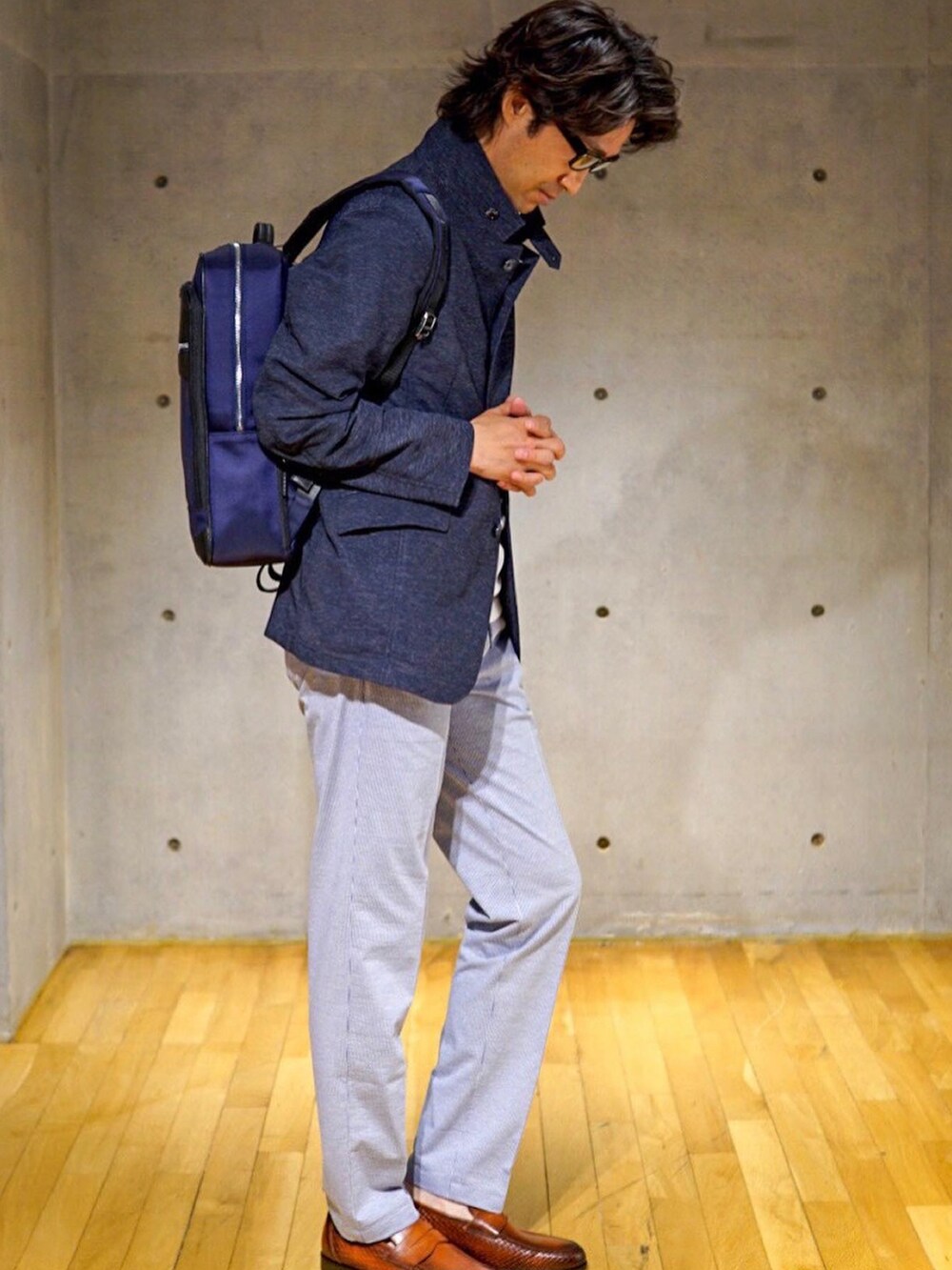 ベージュ系のブルゾン、ブルー系のバックパック/リュックを着用したメンズの春コーディネートの2枚目の写真