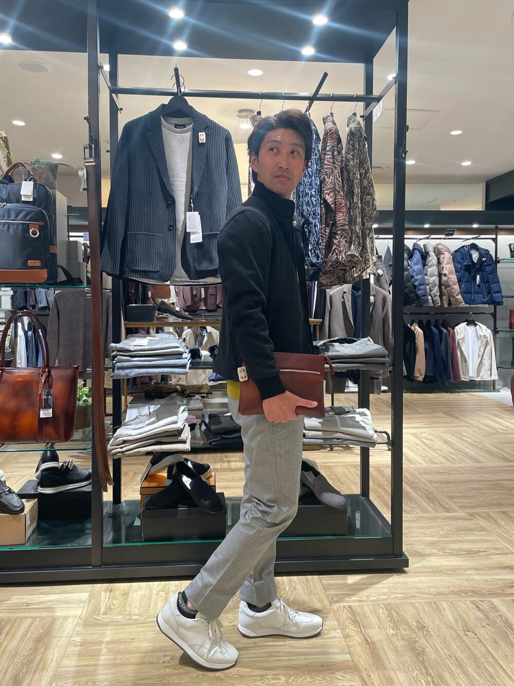 イエロー系のニット/セーター、グレー系のスラックス、グレー系のブルゾンを着用したメンズの秋コーディネートの2枚目の写真