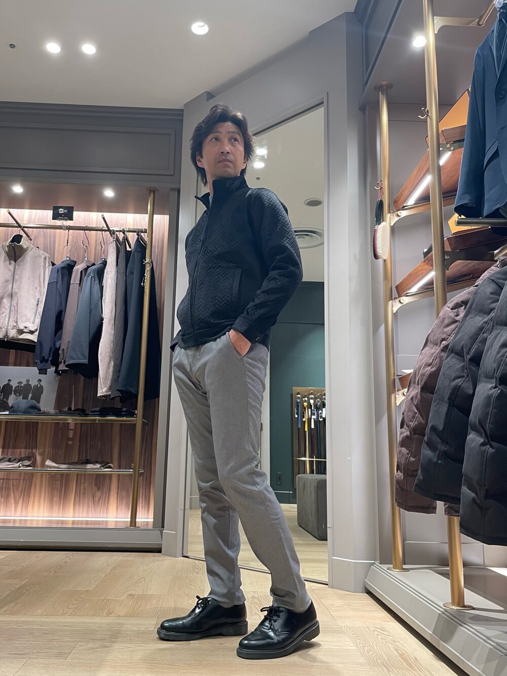 ブラック系のブルゾン、グレー系のその他パンツ、ブルー系のニット/セーターを着用したメンズの冬コーディネートの2枚目の写真