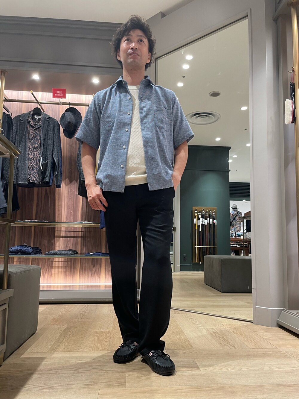ブルー系のシャツ/ブラウス、ブラック系のその他パンツ、ブラック系のモカシン/デッキシューズを着用したメンズの夏コーディネートの4枚目の写真