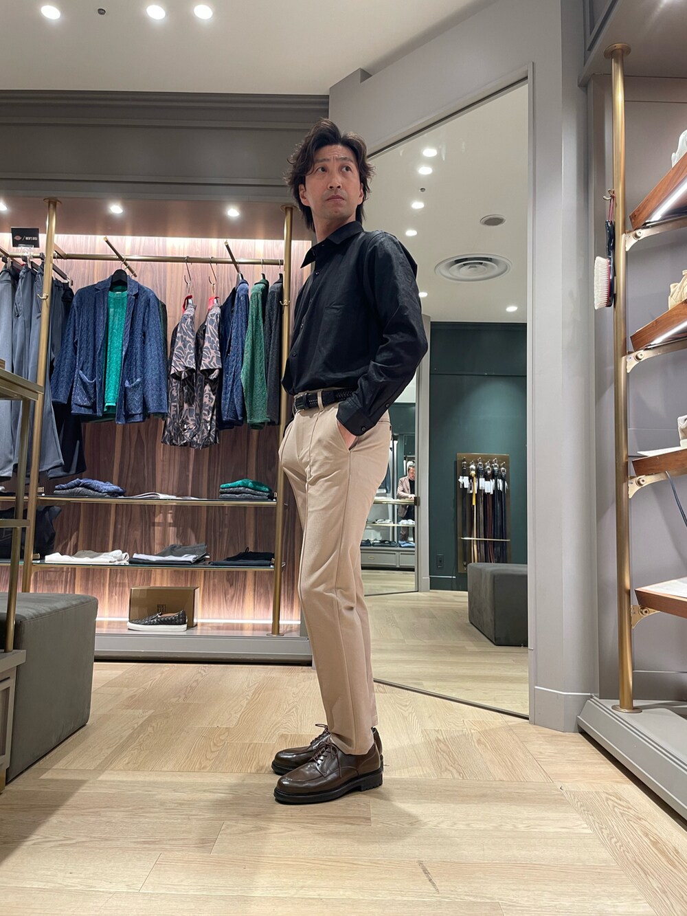 ブラック系のシャツ/ブラウス、ベージュ系のスラックス、ブラウン系のドレスシューズを着用したメンズの春コーディネートの2枚目の写真