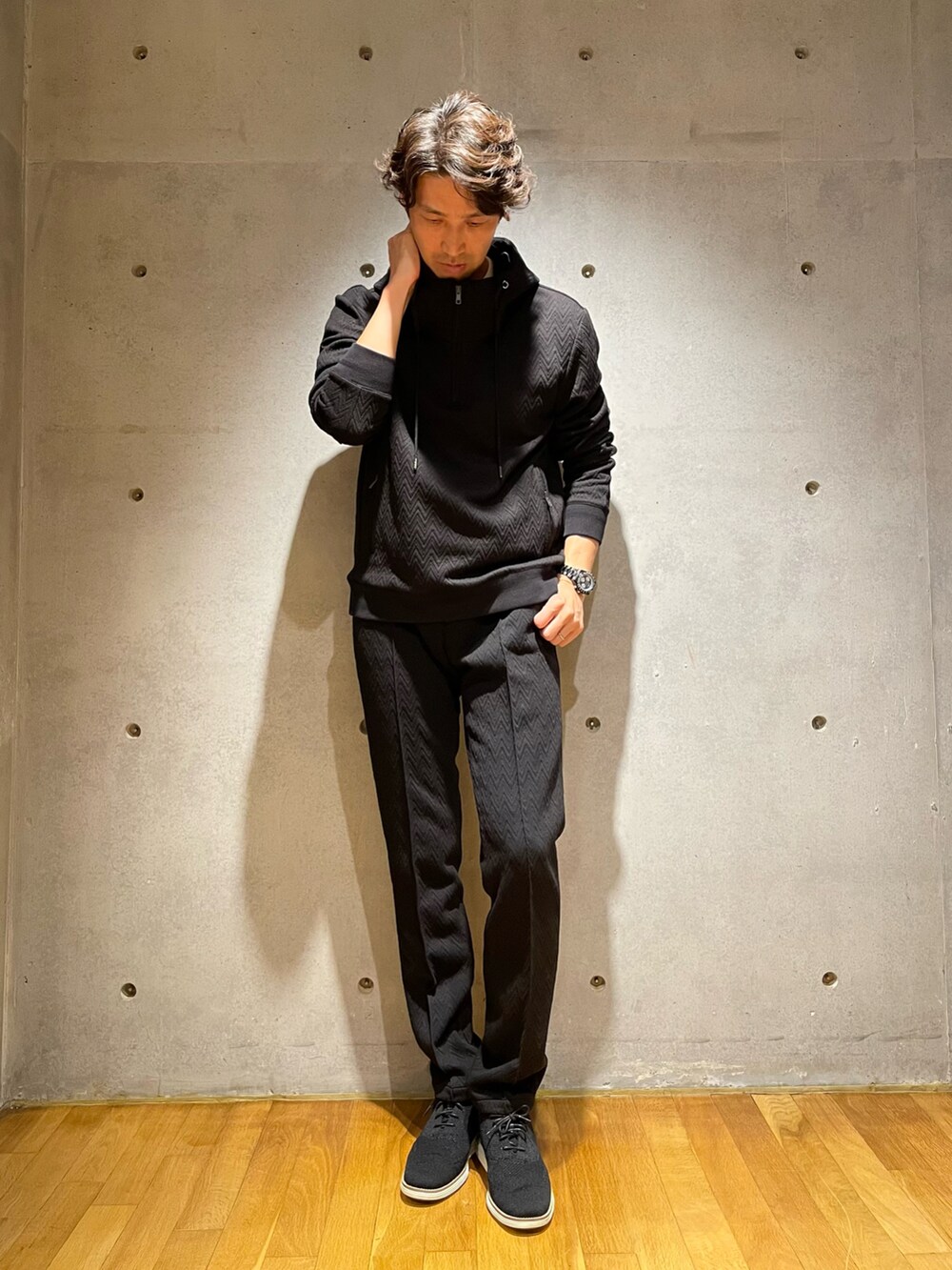 ブラック系のパーカー、ブラック系のスラックス、ブラック系のスニーカーを着用したメンズの秋コーディネートの2枚目の写真