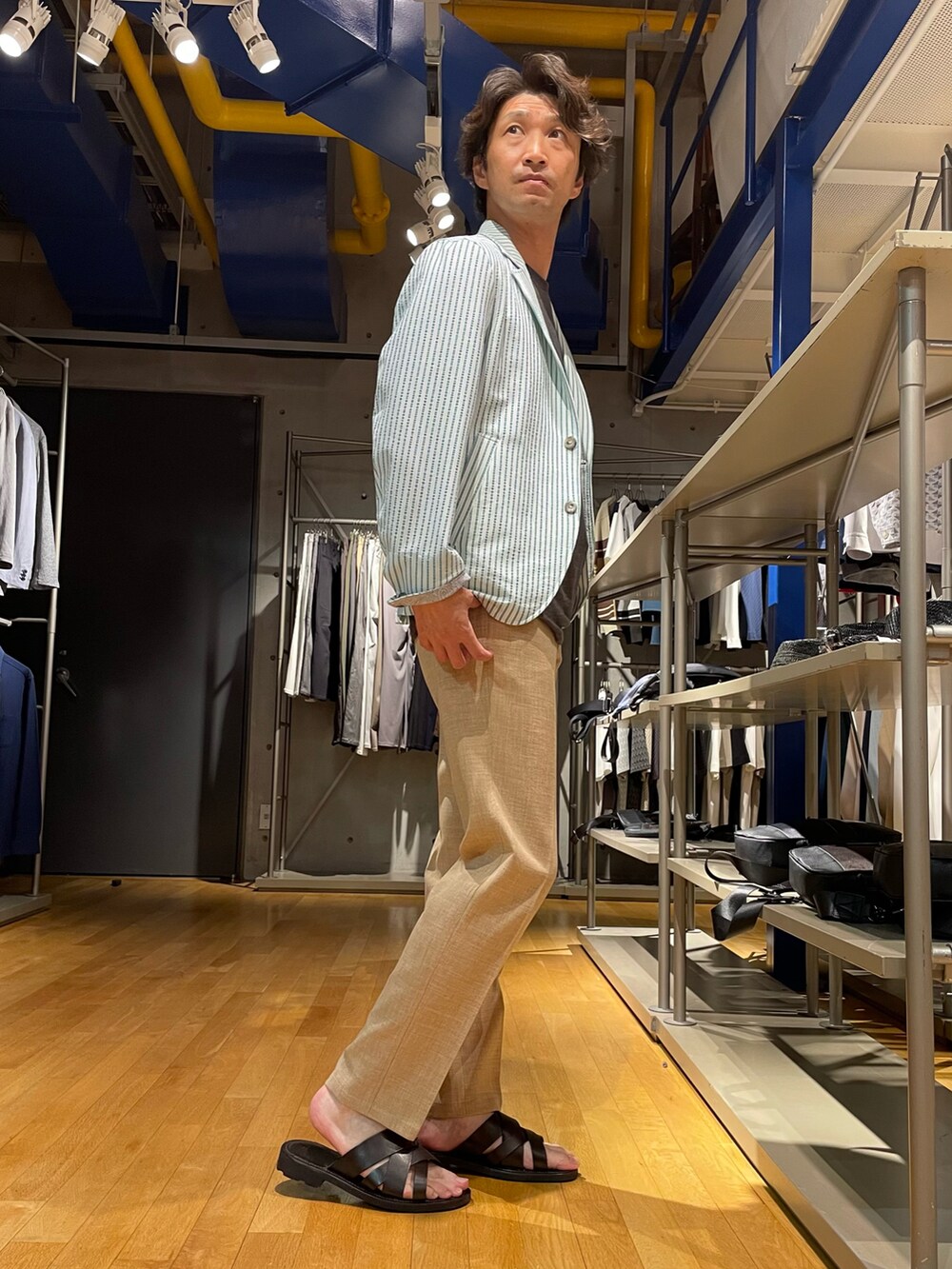 ベージュ系のスラックス、グリーン系のテーラードジャケットを着用したメンズの春コーディネートの2枚目の写真