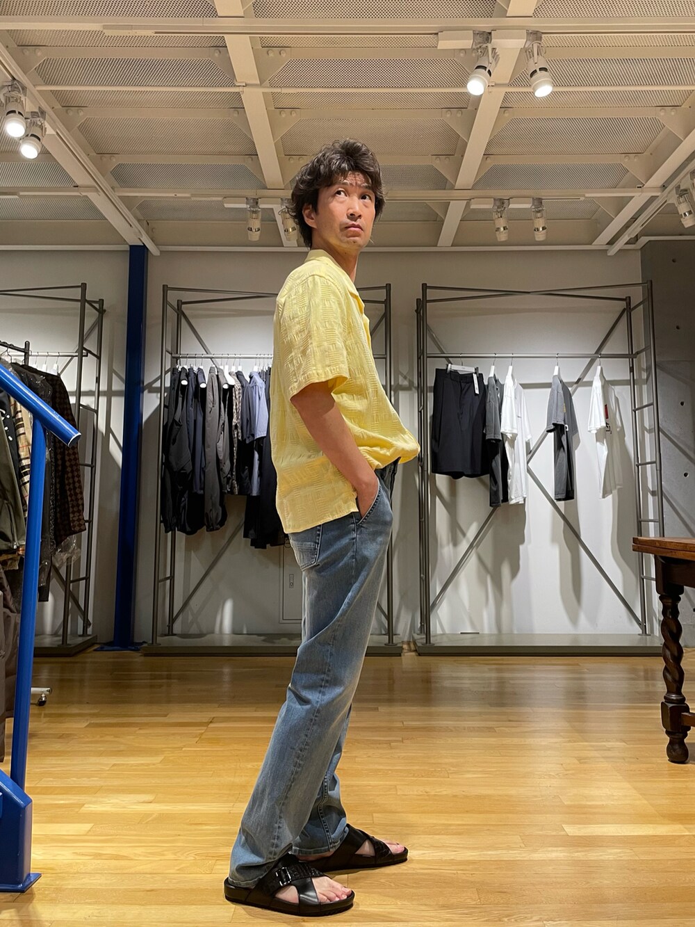 イエロー系のシャツ/ブラウス、ブルー系のデニムパンツ、ブラック系のサンダルを着用したメンズの夏コーディネートの2枚目の写真