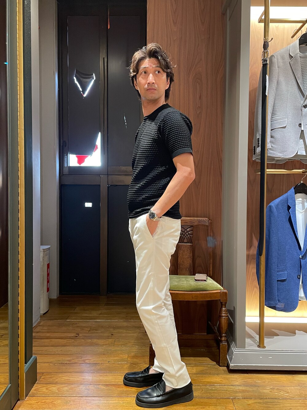 ブラック系のTシャツ/カットソー、ホワイト系のスラックスを着用したメンズの夏コーディネートの2枚目の写真