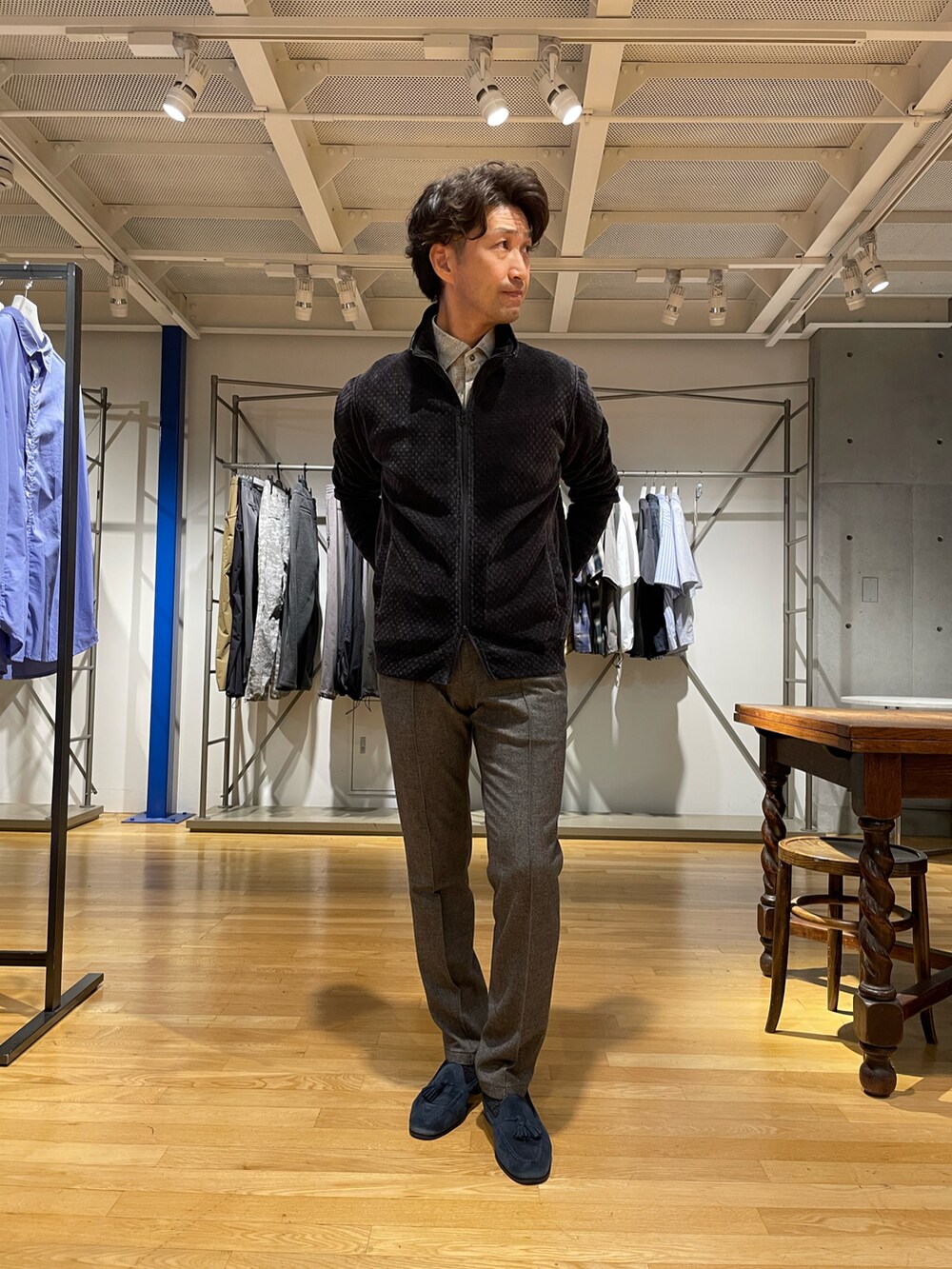 ブラック系のトップス、グレー系のスラックス、ベージュ系のシャツ/ブラウスを着用したメンズの秋コーディネートの2枚目の写真