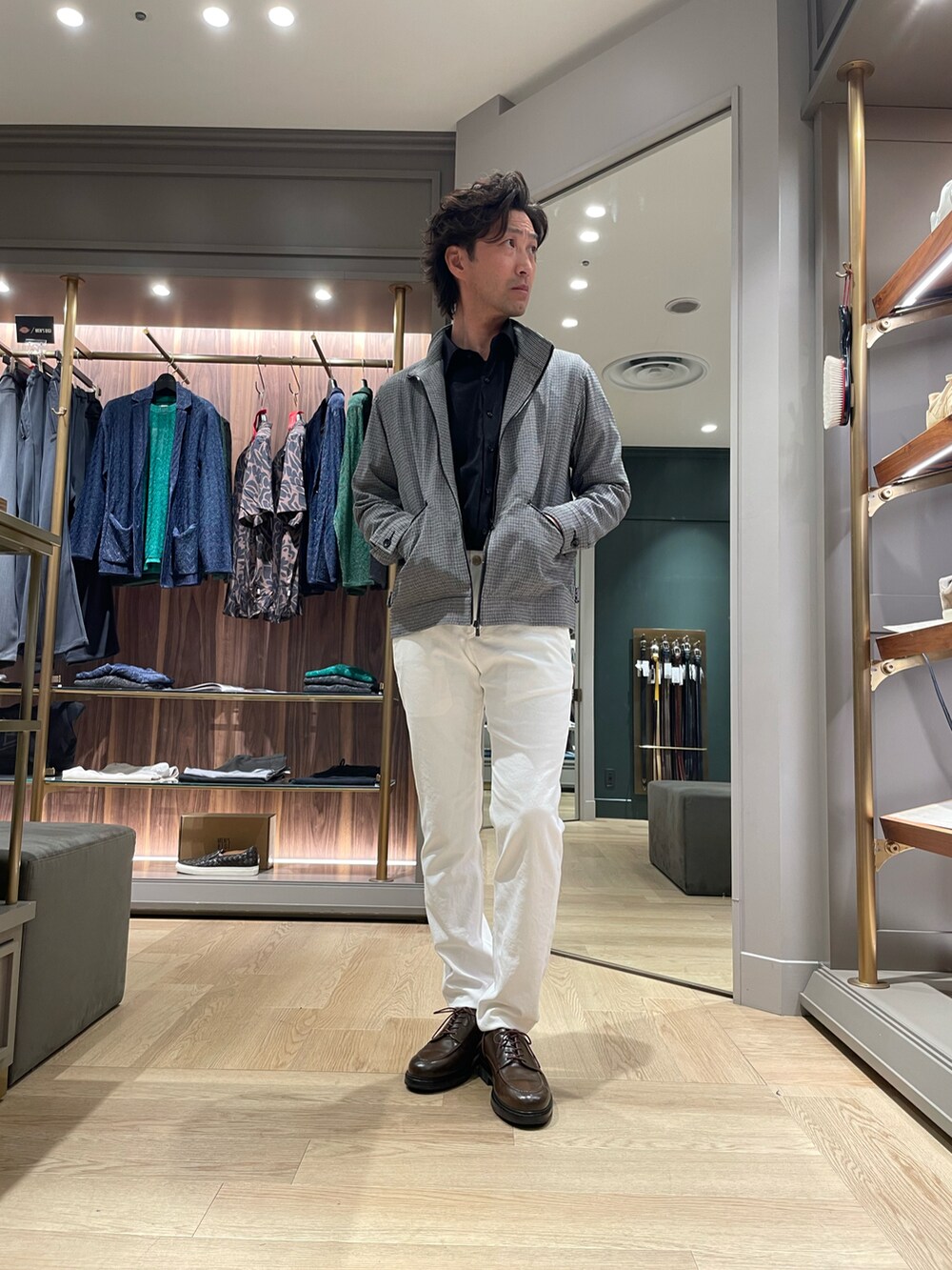 ブラウン系のドレスシューズ、ホワイト系のその他パンツ、ブラック系のブルゾンを着用したメンズの春コーディネートの4枚目の写真