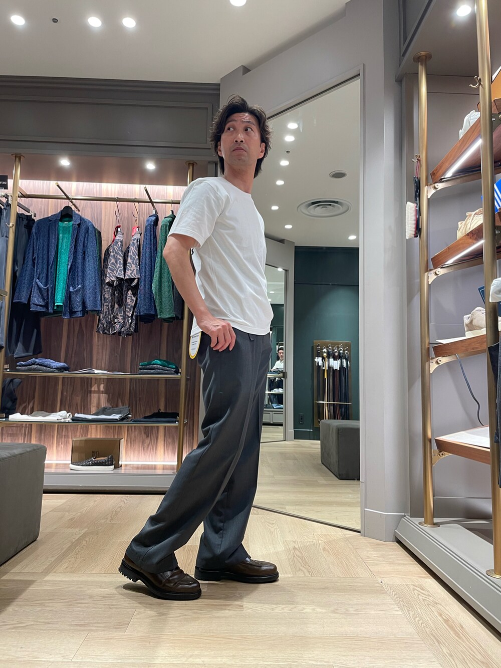 ホワイト系のTシャツ/カットソー、グレー系のパンツ、ブラウン系のドレスシューズを着用したメンズの春コーディネートの4枚目の写真